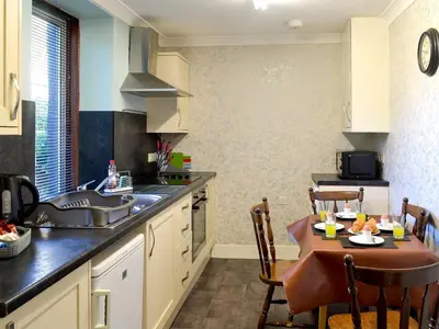 a kitchen with a table and a sink and a counter at Butterhole Farmhouse in Kelton