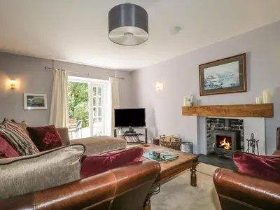 a living room with a couch and a fireplace at Stair Cottage in Keswick