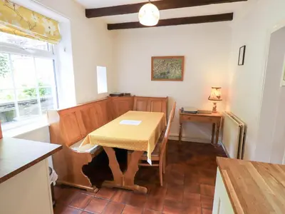 a kitchen with a table and a table and a window at Millcroft in Penrith
