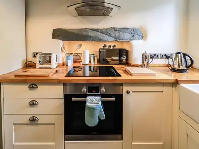 a kitchen with a stove top oven next to a counter at Beck Steps 1 in Grasmere