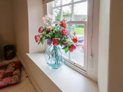 a vase filled with flowers sitting on a window sill at Beck Steps 1 in Grasmere