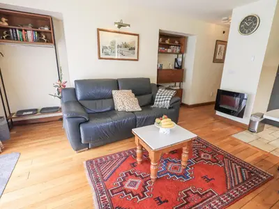 a living room with a leather couch and a coffee table at Stonegarth Cottage in Ambleside