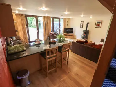 a kitchen and living room with a table and chairs at Stonegarth Mews in Ambleside