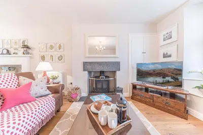 a living room with a couch and a fire place at Poppy's Cottage in Ambleside