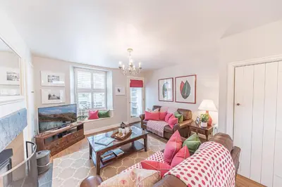 a living room with a couch and a fish tank at Poppy's Cottage in Ambleside