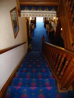 an overhead view of a hallway with blue carpeted stairs at Somerton House Hotel in Lockerbie