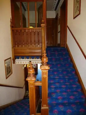 a staircase in a building with a blue carpet at Somerton House Hotel in Lockerbie