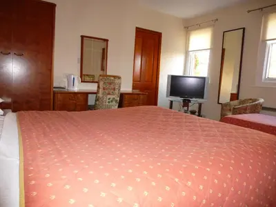 a bedroom with a large bed and a television at Somerton House Hotel in Lockerbie