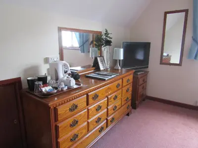 a wooden dresser with a television on top of it at Hunters Lodge Hotel in Gretna Green