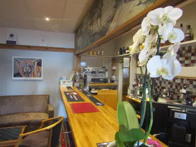 a bar in a restaurant with a counter with white flowers at Hunters Lodge Hotel in Gretna Green