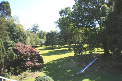 a view of a park with trees and a swing at Cally Palace Hotel & Golf Course in Gatehouse of Fleet
