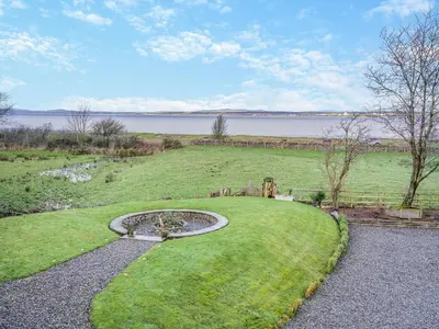 a garden with a fountain in the middle of a field at North Plain Barn in Bowness-on-Solway
