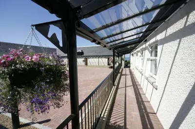 a balcony with a pot of flowers and a hanging plant at Woodland Bay Hotel in Girvan