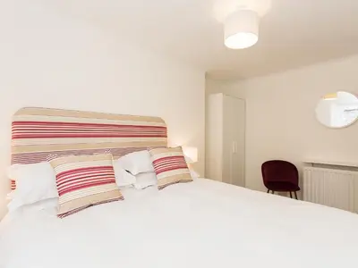a bedroom with a large white bed with two pillows at High Street in Kirkcudbright