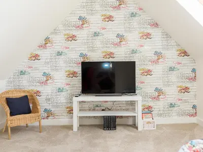 a tv on a stand in front of a wall at High Street in Kirkcudbright