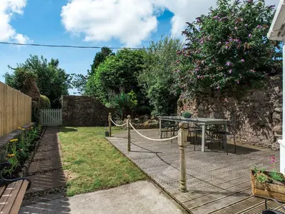 a garden with a table and a fence at High Street in Kirkcudbright
