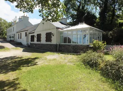 a house with a large glass building at Carrick Beg Self Catering Holiday Accommodation with Hot Tub in Sulby