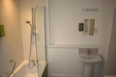 a bathroom with a shower and a toilet and a sink at Derwent Manor Apartments in Keswick