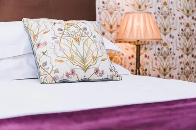 a pillow on top of a bed with a lamp at Portland House in Keswick