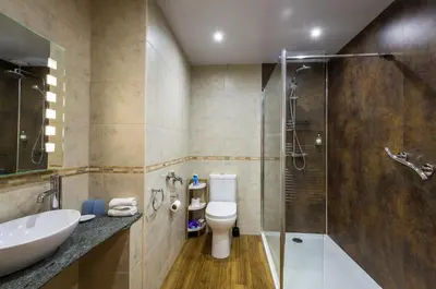 a bathroom with a toilet and a sink and a shower at Portland House in Keswick