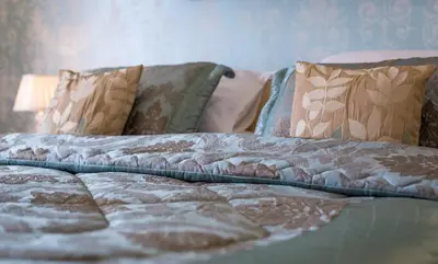 an unmade bed with pillows on it in a bedroom at The Inn at Ravenglass in Ravenglass