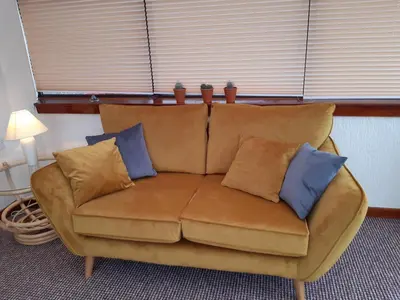 a brown couch with pillows on it in a room at Leafield Holiday Home in Stranraer