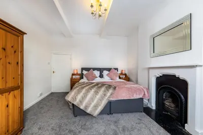a bedroom with a bed and a fireplace at Muncaster Cottages in Ravenglass