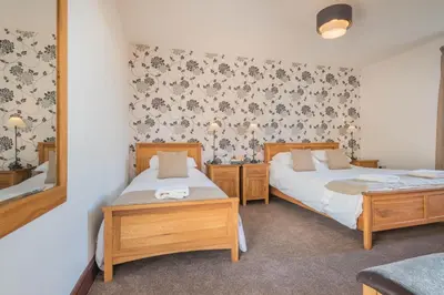 a bedroom with two beds and a mirror at Big White House in Cockermouth