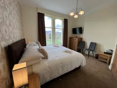 a bedroom with a large bed and a window at Brundholme in Keswick