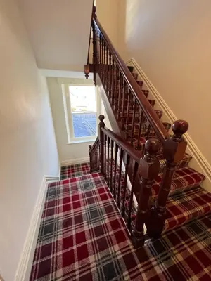 a stairway with a plaid carpet at Brundholme in Keswick