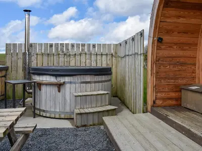 a wooden fence with a hot tub next to a wooden door at Withy Bottom-Uk1393 in Corney