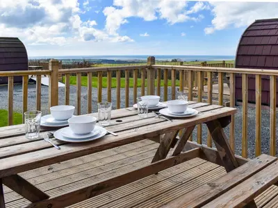 a wooden table with plates and glasses on a deck at Stainton-Uk1395 in Corney
