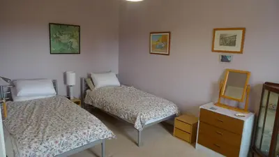 a room with two beds and a mirror and a dresser at Bonshawbrae in Kirtlebridge