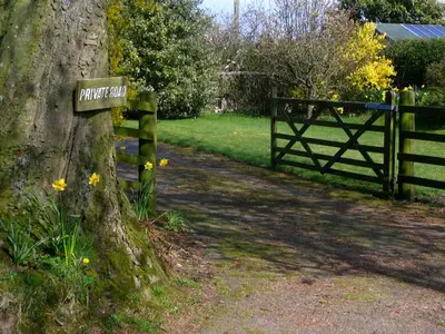 a sign on a tree next to a fence at Bonshawbrae in Kirtlebridge