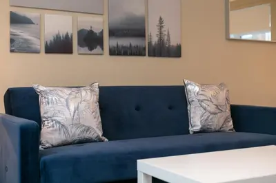 a blue couch with two pillows on it in a living room at Cairn Suite - Donnini Apartments in Ayr