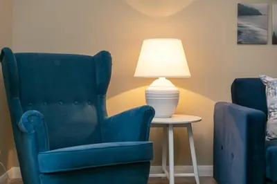 two chairs and a table with a lamp on it at Cairn Suite - Donnini Apartments in Ayr