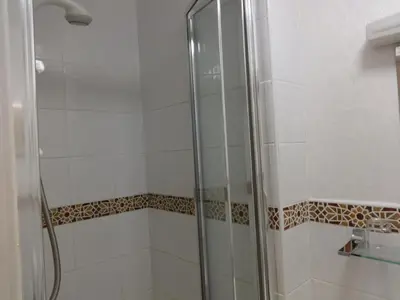 a shower with a glass door in a bathroom at Aberdour Guest House in Dumfries