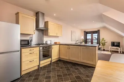 a kitchen with wooden cabinets and a white refrigerator at Elliot Suite No9 - Donnini Apartments in Ayr