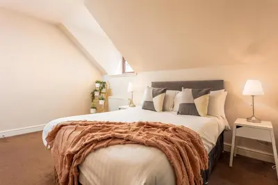 a bedroom with a large bed in a attic at Elliot Suite No9 - Donnini Apartments in Ayr