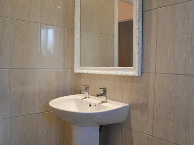 a bathroom with a white sink and a mirror at Alan's Cottage in Cockermouth