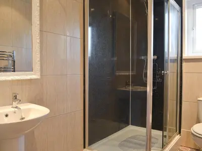 a bathroom with a shower and a sink at Alan's Cottage in Cockermouth