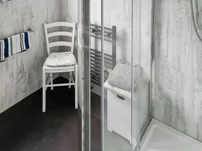 a white chair in a room with a refrigerator at Wavecrest in Mainsriddle