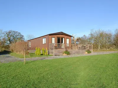 a small wooden house in a field with a yard at Watches - Uk13544 in Bassenthwaite