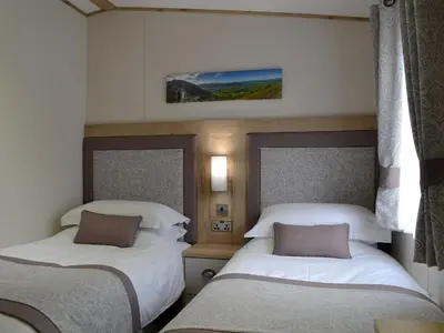 a bedroom with two beds and a tv on the wall at Watches - Uk13544 in Bassenthwaite