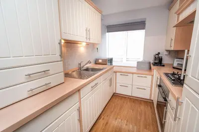 a kitchen with white cabinets and a sink at Fellseeker in Keswick