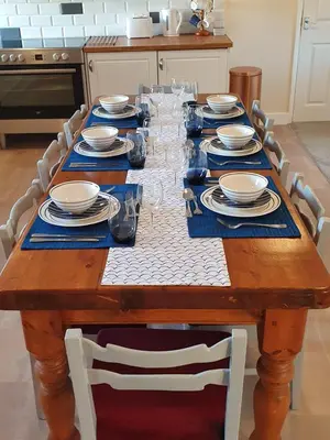 a wooden table with plates and dishes on it at Lovely Cottage on Hadrians Wall 12 Miles From Carlisle in Carlisle