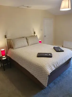 a bedroom with a bed with two black shoes on it at Lovely Cottage on Hadrians Wall 12 Miles From Carlisle in Carlisle