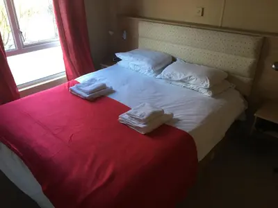 a bedroom with a large bed with towels on it at STUNNING LODGE - HOME FROM HOME Kippford, Dalbeattie in Dalbeattie