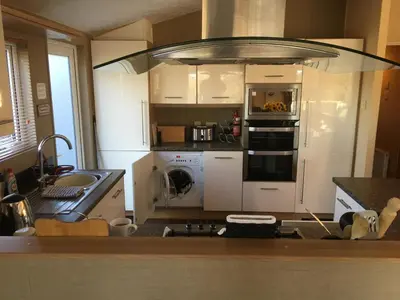a kitchen with a sink and a stove top oven at STUNNING LODGE - HOME FROM HOME Kippford, Dalbeattie in Dalbeattie