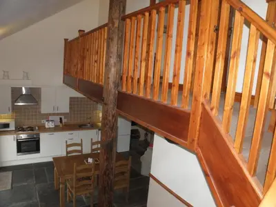 a kitchen with a wooden staircase in a house at DAIRY MAIDS COTTAGE in Seascale